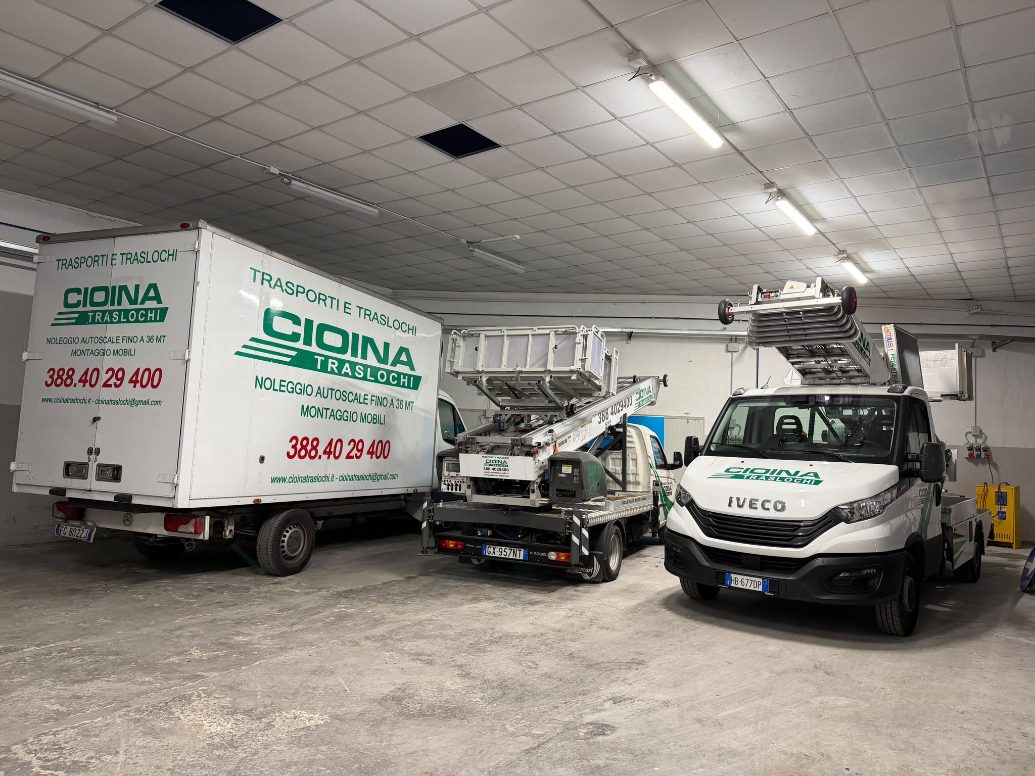 Tre mezzi Cioina Traslochi parcheggiati nel deposito aziendale: camion furgonato e due autoscale