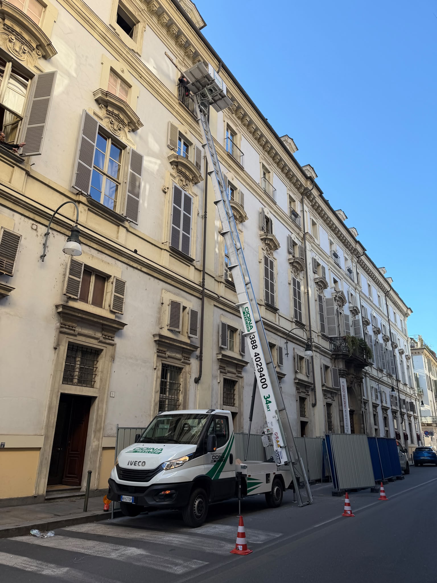 Autoscala da 34 metri estesa al terzo piano di un palazzo storico, con coni e transenne in strada