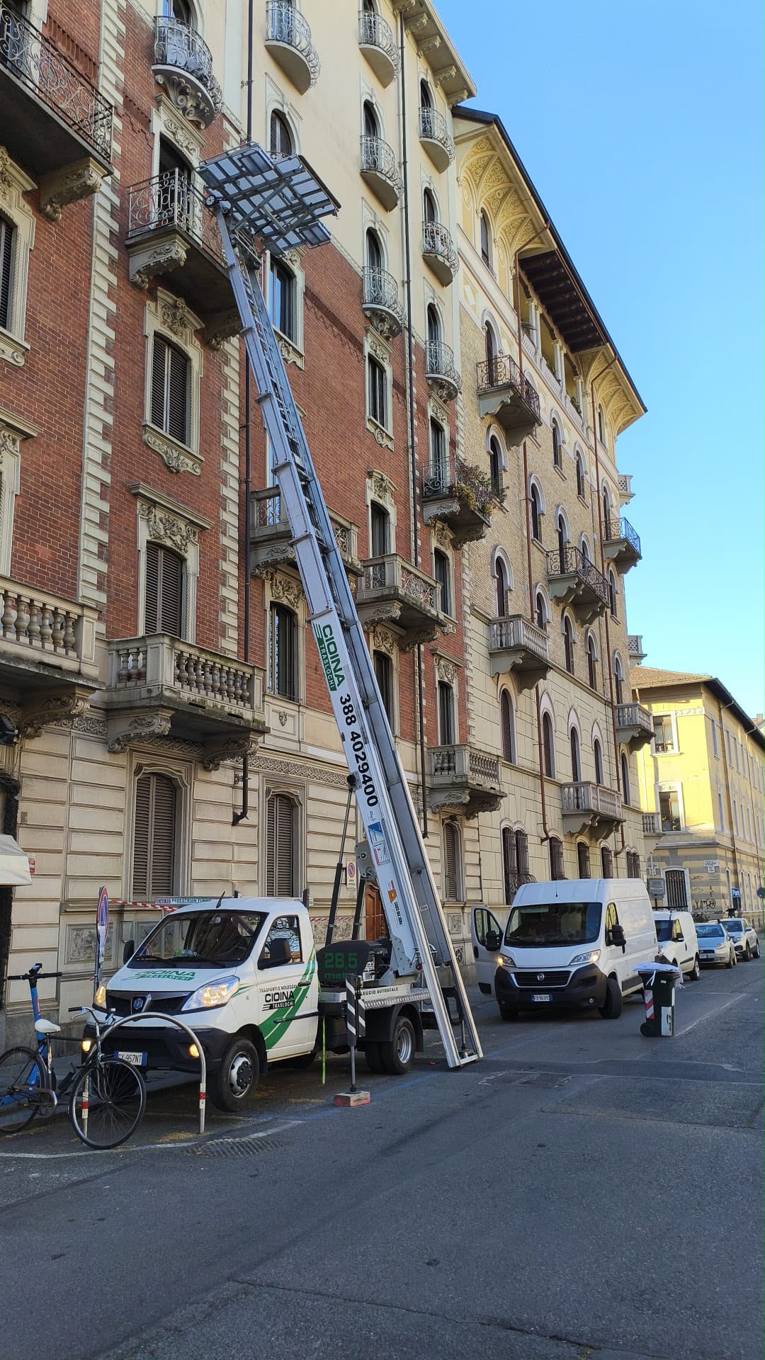 Autoscala estesa lungo la facciata di un palazzo d'epoca con balconi in ferro battuto