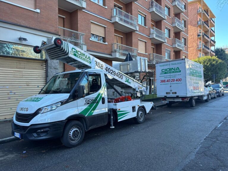 Autoscala e camion Cioina Traslochi parcheggiati in fila davanti a un palazzo in mattoni