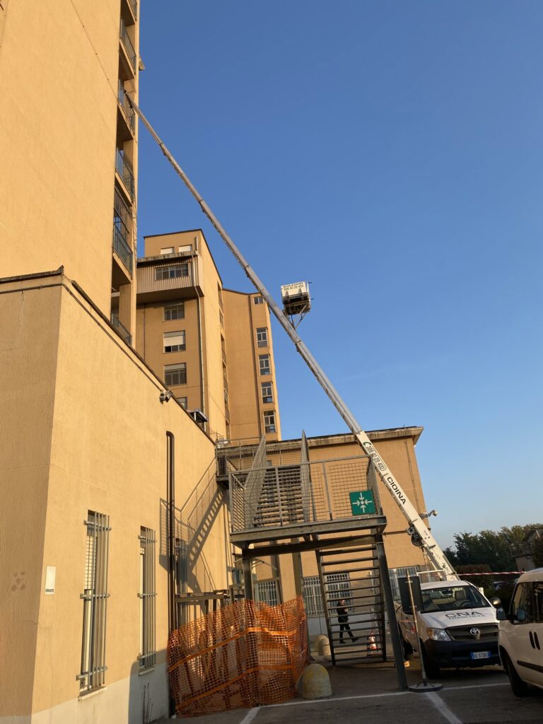 Autoscala estesa lungo un edificio alto, vista dal cortile interno